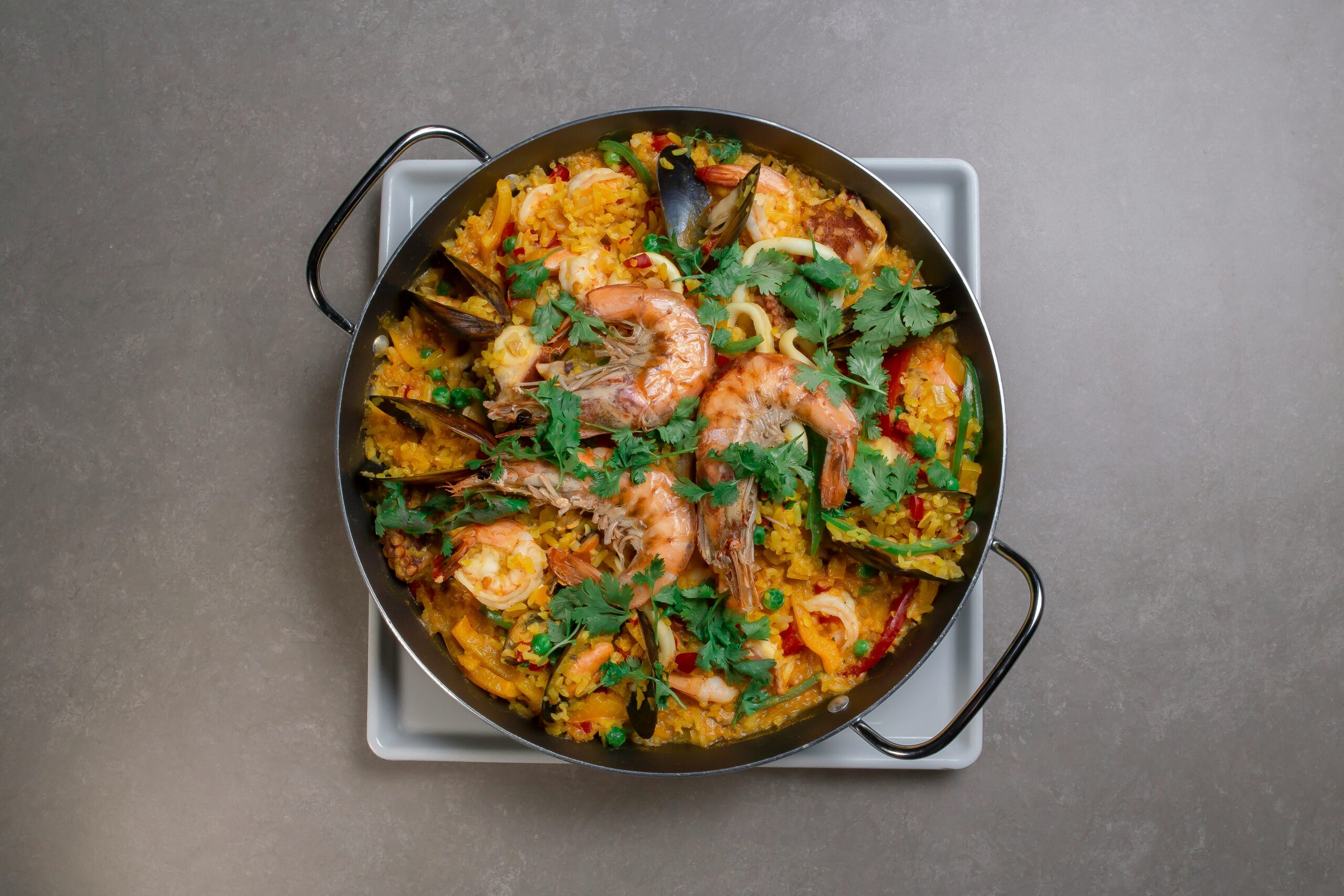 Een luxe paella met kreeft en zeevruchten geserveerd